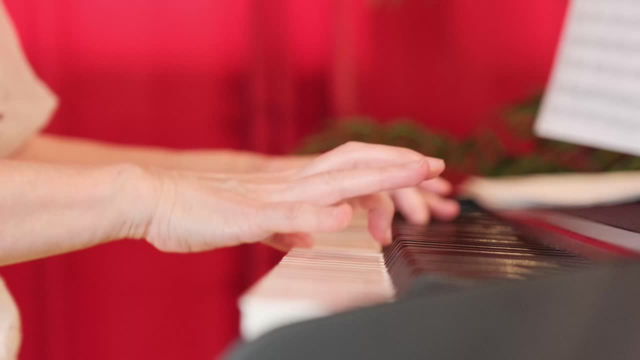 Rallentamento al rallentatore di mani aggraziate che suonano i tasti del piano, ripreso con un movimento laterale fluido e un'illuminazione soffusa per un'atmosfera musicale intima