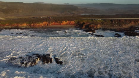 aerial drone zoom in of coast of pescadero state beach during sunset