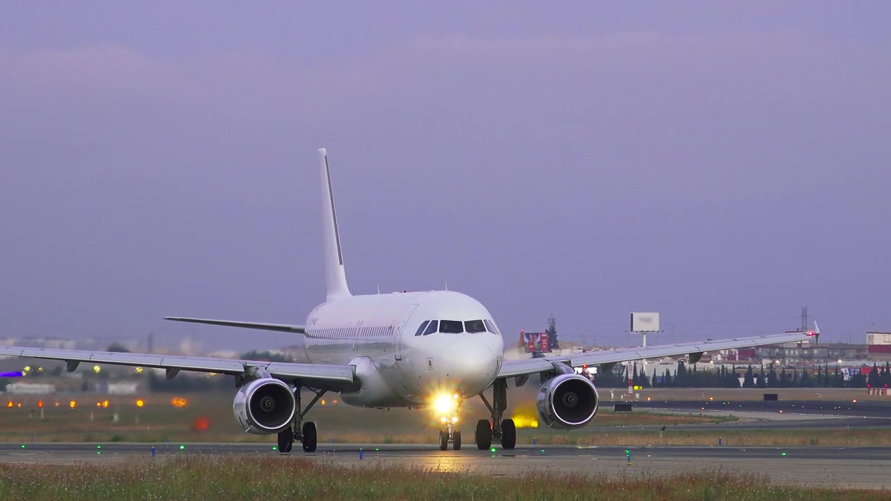 Aereo passeggeri bianco in decollo dalla pista dell'aeroporto al tramonto