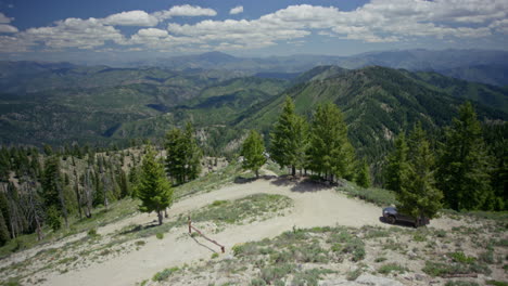 Panning-up-from-dirt-road-to-vast-forested-mountain-range-in-national-forest