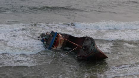 a wrecked rusty old ship washed ashore on a beach filmed in slow motion in lagos, nigeria