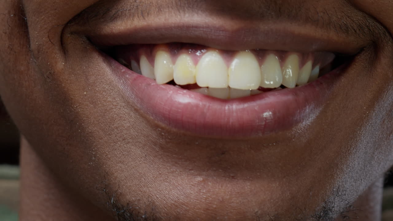 Macro shot of male model showing candid smile and moving lips