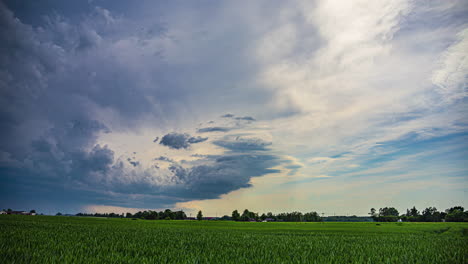 Massive-cyclone-of-storm-clouds-flowing-over-rural-landscape,-time-lapse