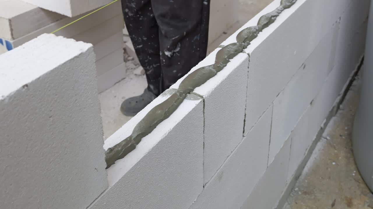 Watch skilled workers laying blocks to create a sturdy wall showcasing ...