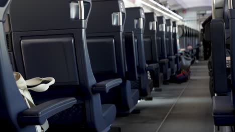 vista de cerca de las filas de asientos dentro de un tren de pasajeros que se mueve a lo largo de las vías en el reino unido