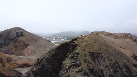 aerial 360 of hikers standing atop massive and steep cliffside