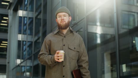 man with coffee and laptop on city street