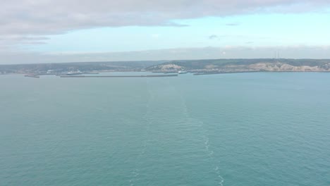 wide aerial shot from the sea of ferry leaving dover harbour