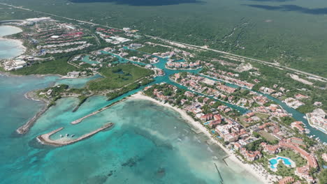 rotation-aerial-view-of-a-coastal-city,-full-of-vibrant-architecture-and-pristine-beaches-surrounded-by-the-majestic-sea-in-Mexico