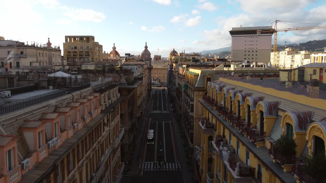 Ripresa con drone di strada e piazza nel centro di Genova con case alte.