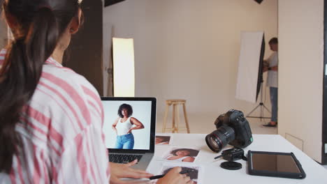 fotógrafa profesional que trabaja en un estudio con asistentes en el fondo