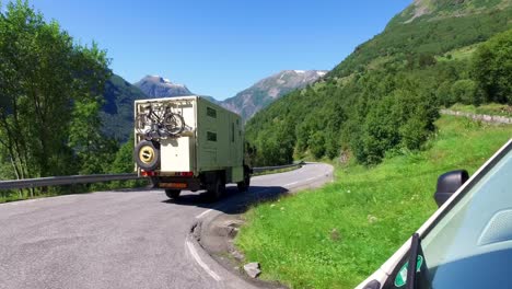 couple goes on a mountain road in norway by camper van rv.