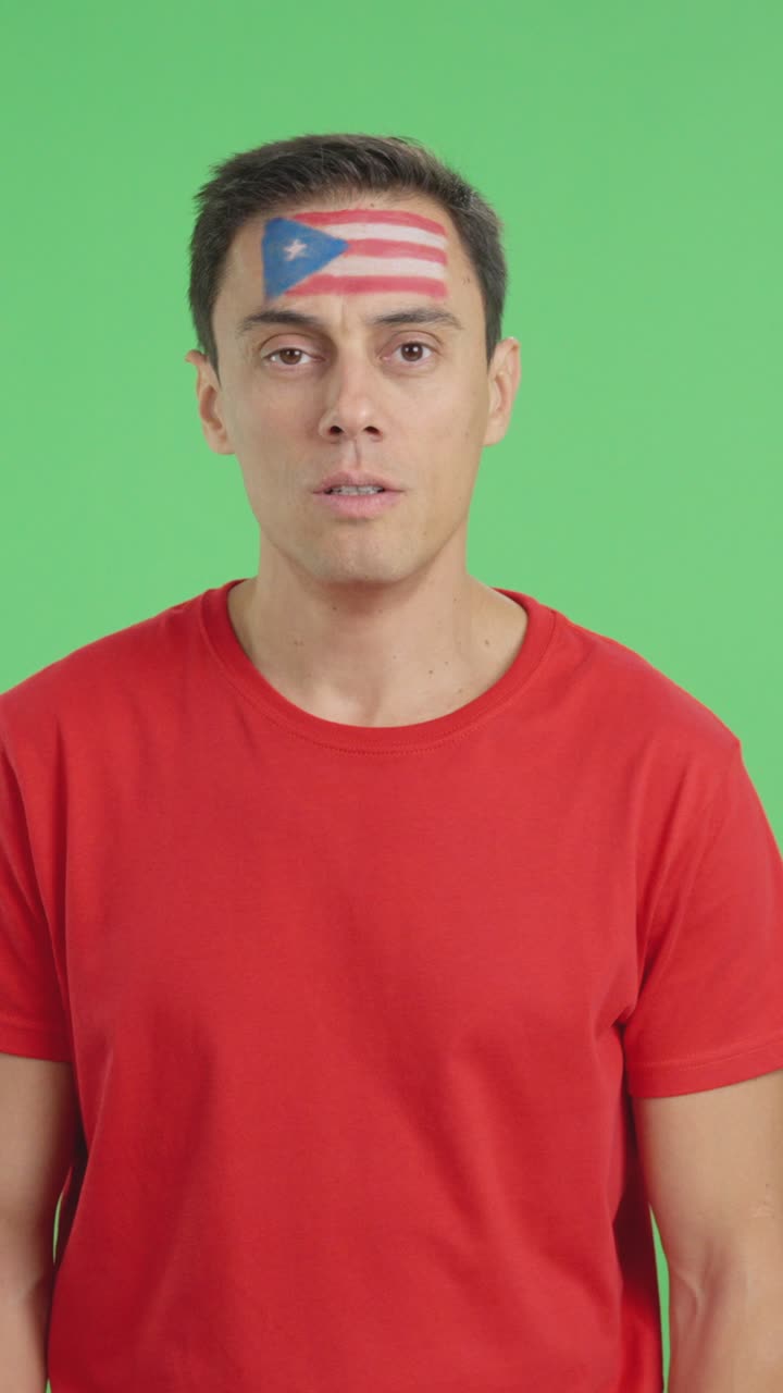 Man standing with puerto rican flag painted on face smiling