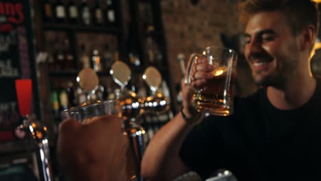 Two-happy-male-friends-toasting-a-glasses-of-beer