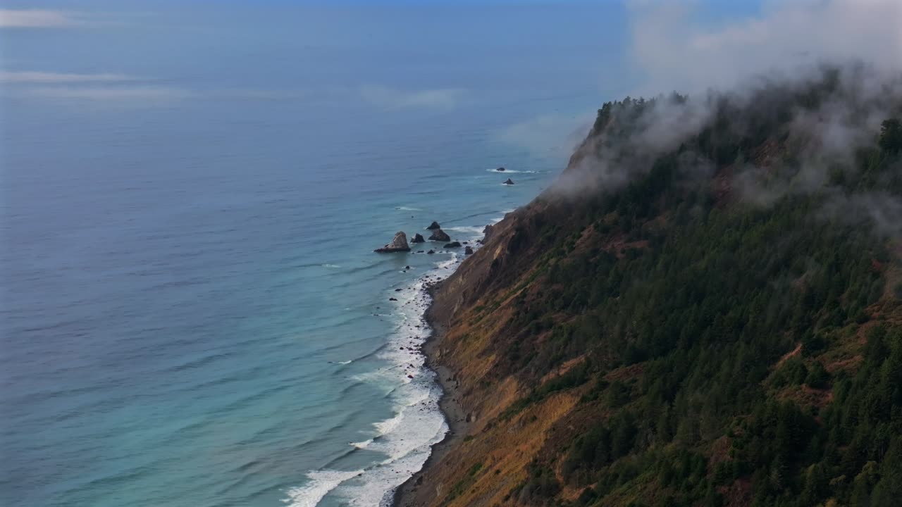 Lost Coast Trail Sinkyone Wilderness sunny clear blue sky morning misty rugged surf rocky mountainside cliffs bluffs untouched remote USAL Beach campground California aerial drone camping static shot