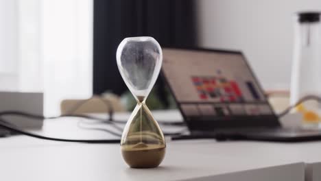 Hourglass-sand-clock-in-office,-time-management-for-better-productivity,-closeup-shot