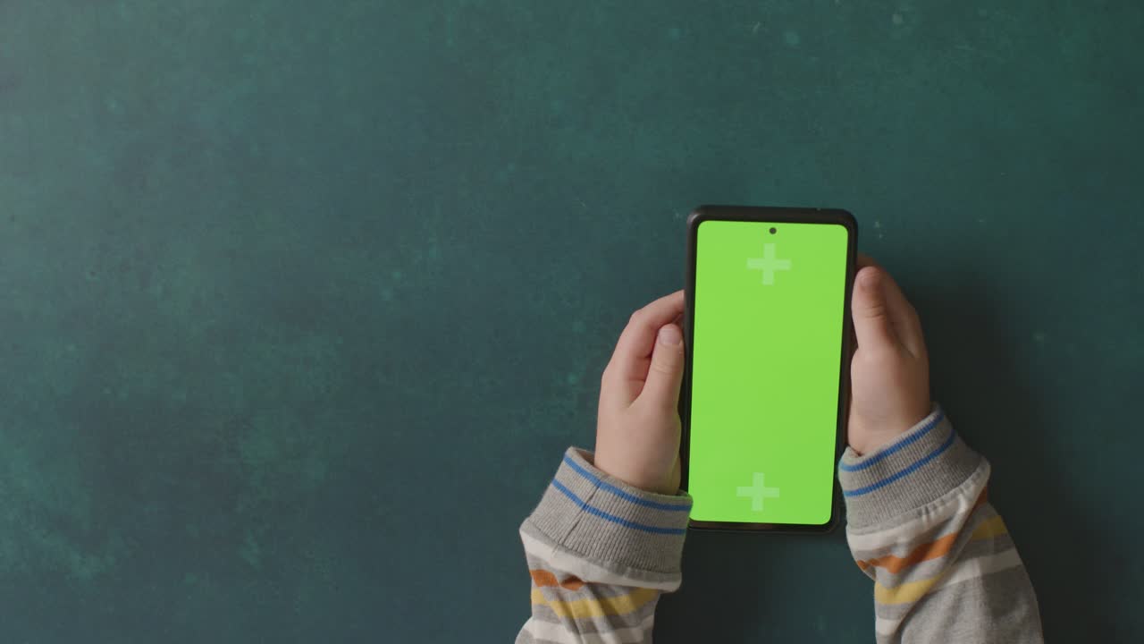 toma de estudio aérea de un niño usando un teléfono móvil de pantalla verde 5