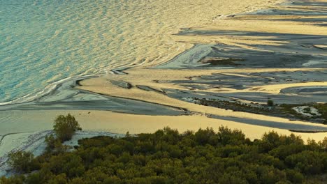 golden hour glow of light reflects across river floodplain delta meeting lake