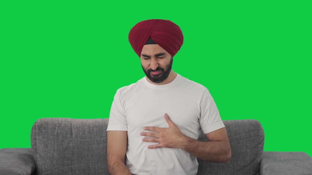 Sick Sikh Indian man suffering from acidity Green screen