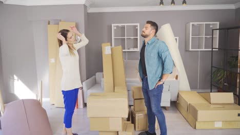 married couple moving into their new home placing items.