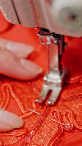 woman sews clothes on sewing machine. woman hands drawing pattern on fabric with sewing machine vertical video