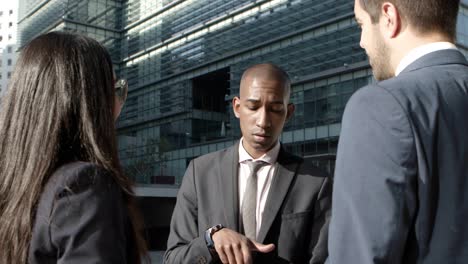 Young-coworkers-discussing-project-on-street