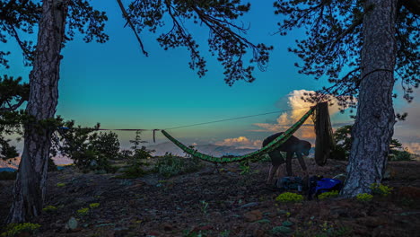 timelapse of a hiker setting up camp with a hamoc to relax in outdoors