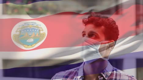 animation of flag of costa rica waving over man wearing face mask during covid 19 pandemic