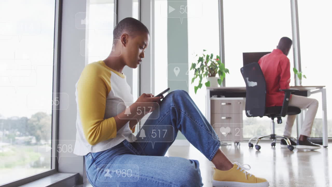 Animation of icons with numbers over african american businesswoman using smartphone in office