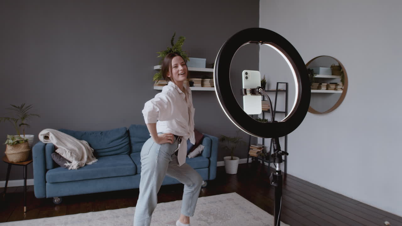 mujer bonita y joven bailando frente a la cámara de su teléfono inteligente para subirlo a las redes sociales