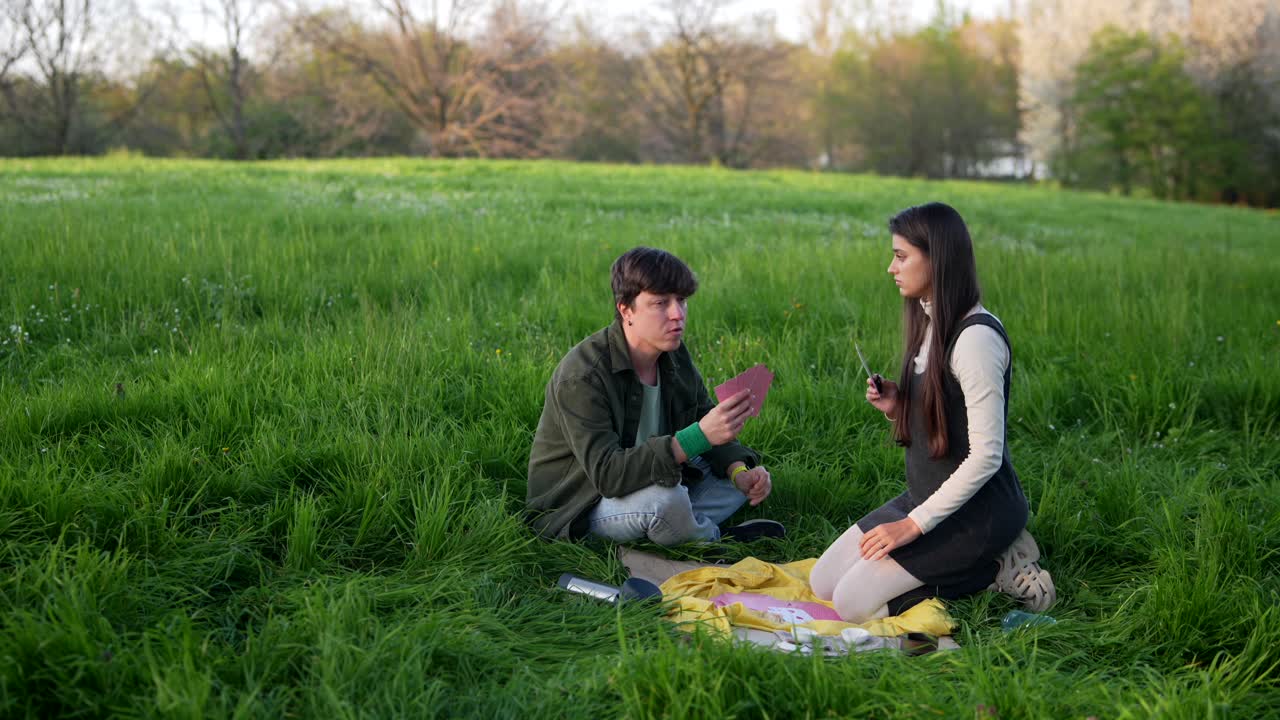 Friends playing cards in a park