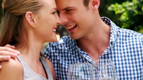 smiling romantic couple toasting wine glasses