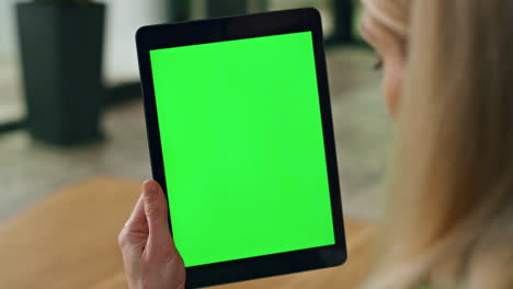 lady finger swiping greenscreen tablet at office. anonymous woman surfing web