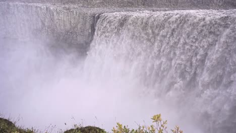 powerful foaming waterfall falling from slope