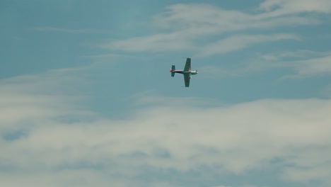 Ein-Kleines-Flugzeug-Fliegt-Mit-Wolken-Durch-Den-Blauen-Himmel