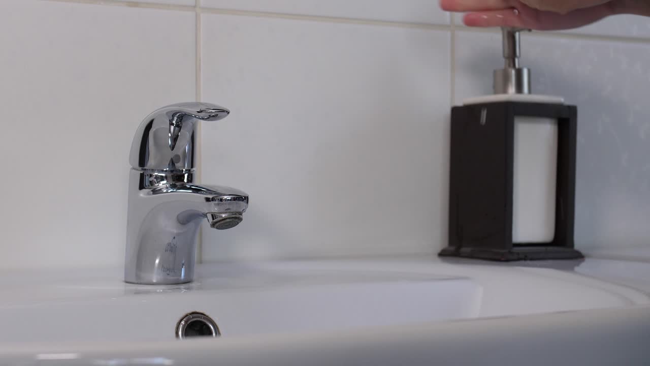 lavarse las manos femeninas a fondo con jabón, plano medio