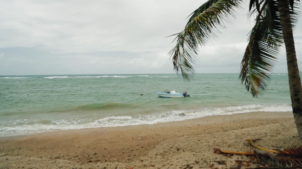 Boat anchored in the middle of a beautiful blue water bay in Tobago