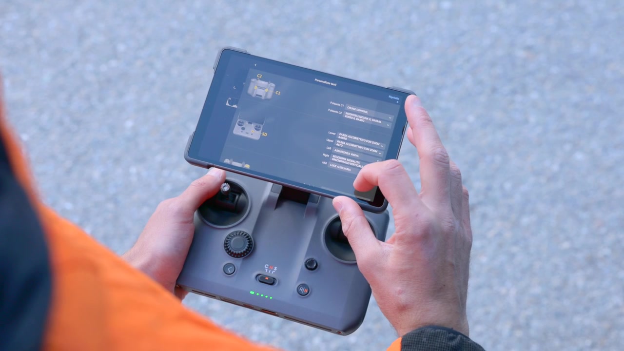 Hands adjust settings on a tablet-mounted drone controller before flight. Pre-flight configuration and safety checks for aerial filming