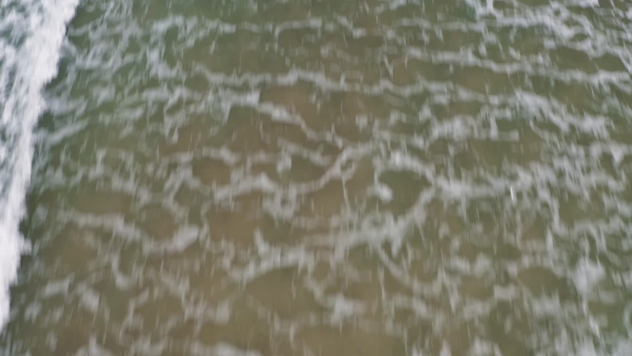 Lågflygande drönare med tilt-tagning från vattnet och stranden till klipporna vid "Traigh Mhor" i Tolsta på Yttre Hebriderna i Skottland
