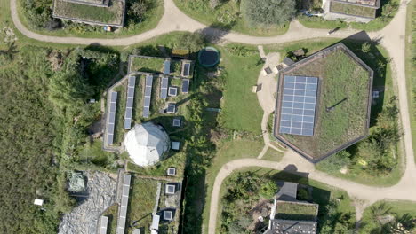 top down aerial of solar panels on rooftops on beautiful earthship homes