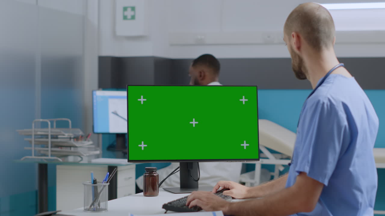 Doctor using computer with green screen in hospital
