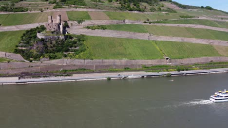 Sightseeing-Excursion-boat-cruising-past-Ehrenfels-Castle-up-the-River-in-upper-middle-Rhine-valley,-Germany