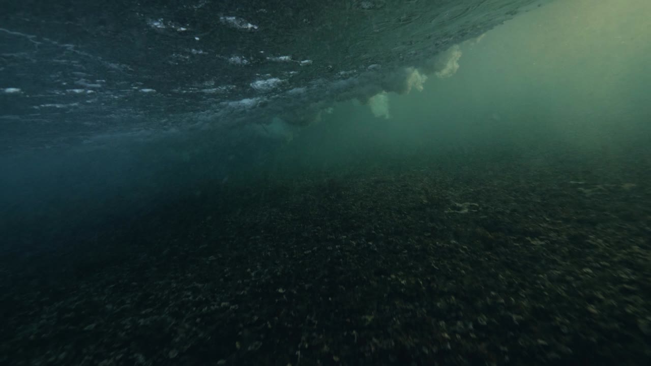 las olas circulares del océano rompen en la superficie submarina espumas y burbujas.