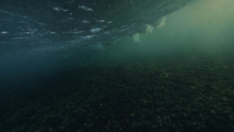las olas circulares del océano rompen en la superficie submarina espumas y burbujas.