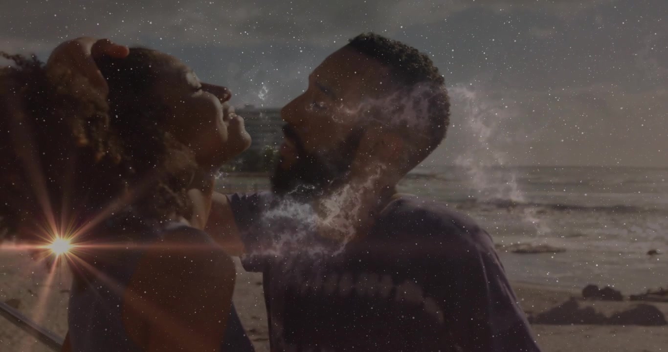 Film couple leaning in for kiss on beach, man raising hand sparking nebula swirl lens flare