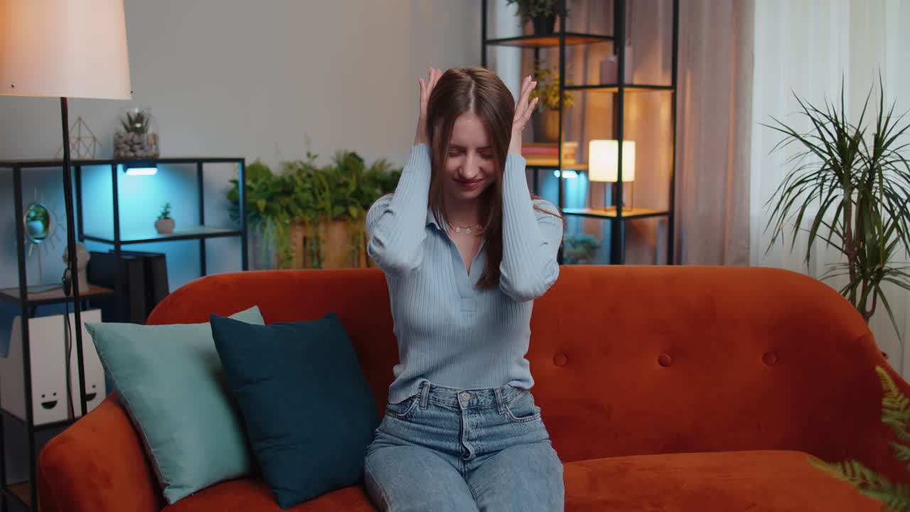 trabajo de reparación en los vecinos concepto, chica irritada en casa cubrir las orejas con almohadas molestado por el ruido