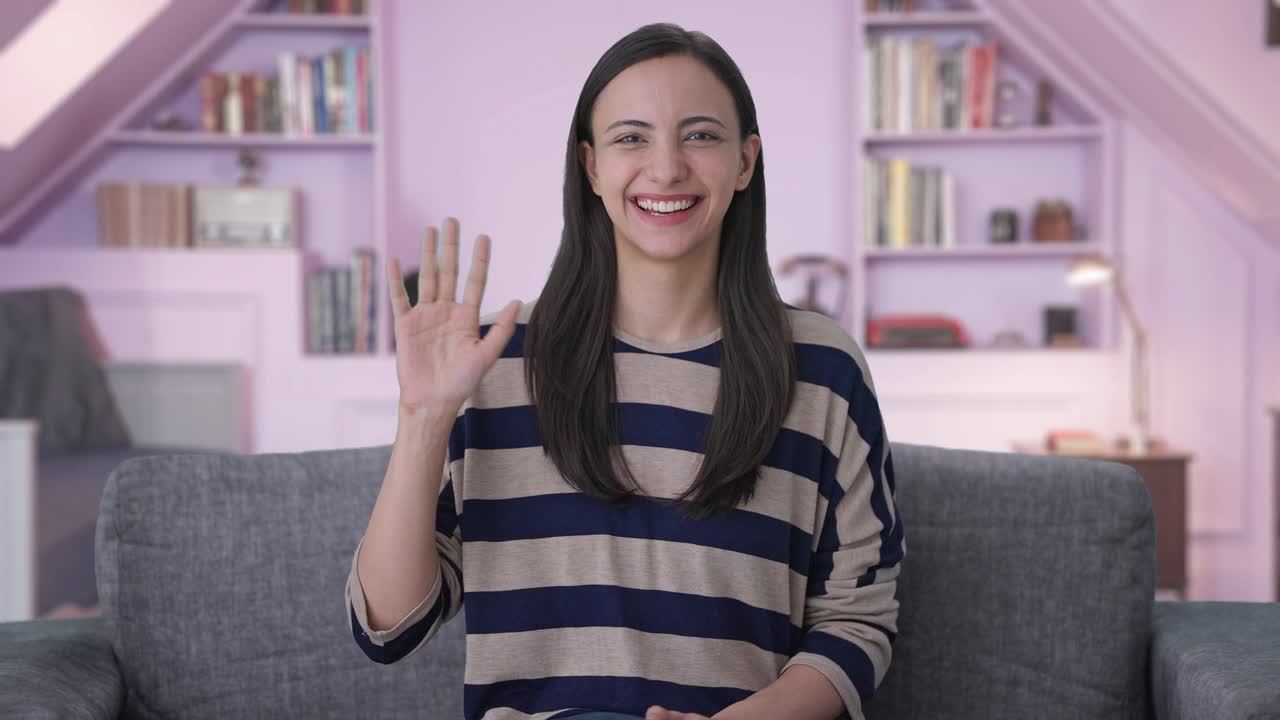 chica india feliz saludando a la cámara