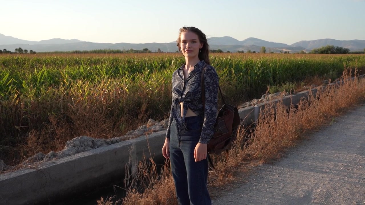 Una ragazza nella natura che cattura un momento squisito e sereno, circondata dai campi