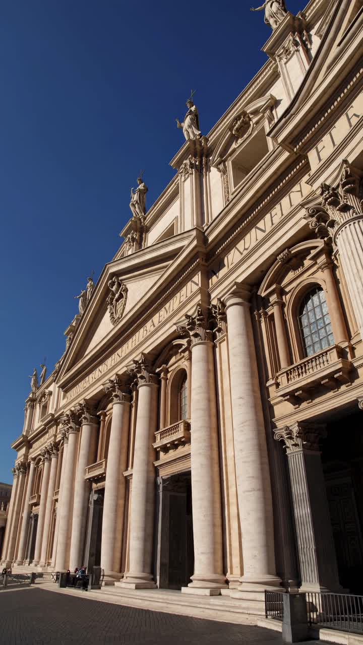 Inquadratura grandangolare di una grandiosa cattedrale sotto un cielo azzurro e sereno, che ne cattura la maestosa architettura.
