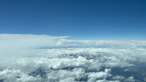 Cumulus-clouds-against-blue-sky-over-mountain-range